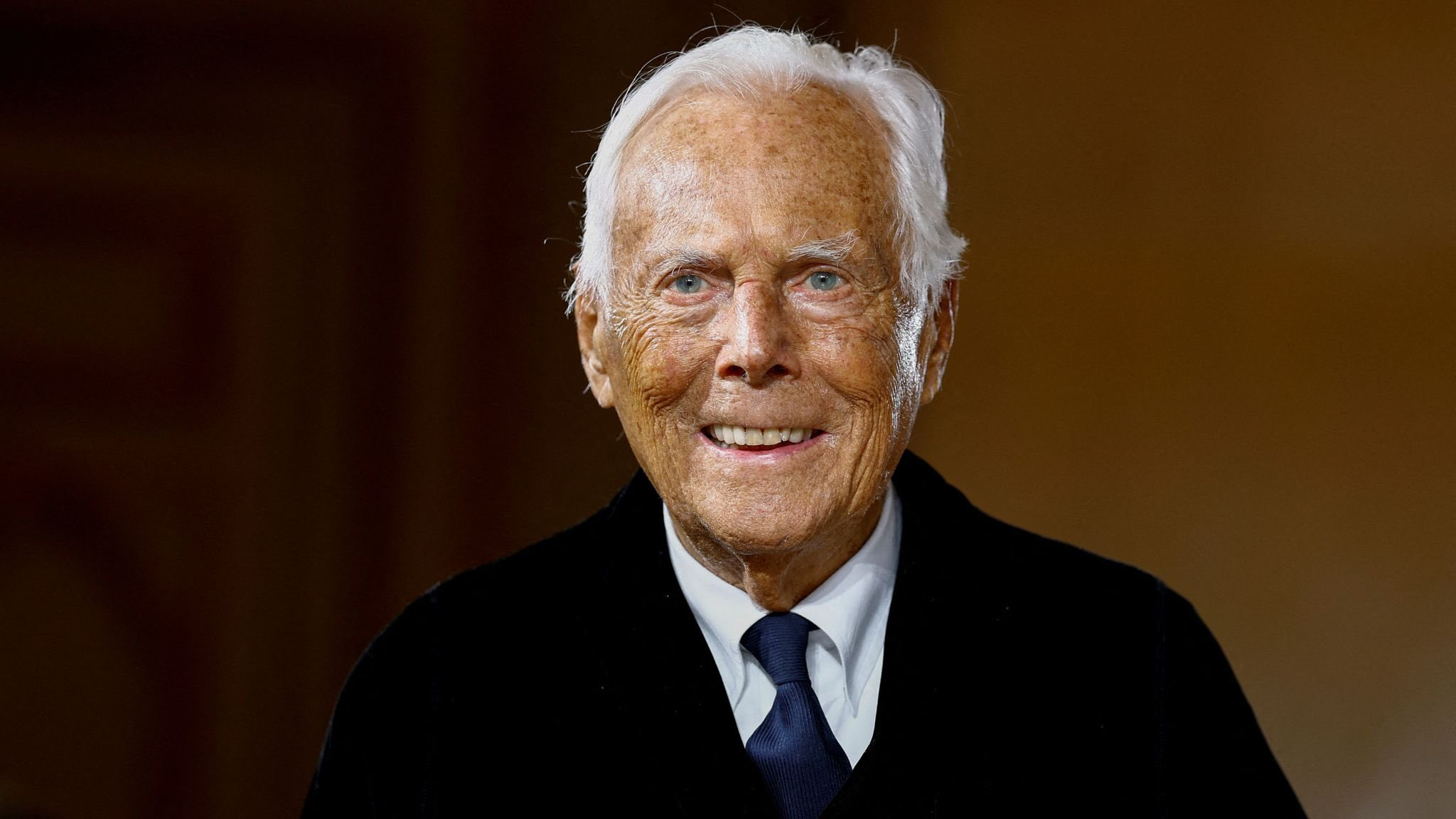 Giorgio Armani smiling at a fashion show in Milan